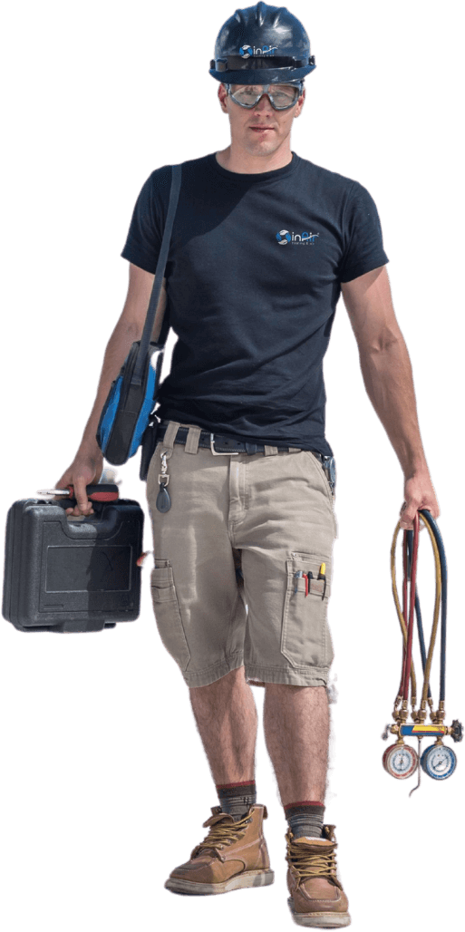 A worker wearing a black helmet, black t-shirt, beige cargo shorts, and brown boots carries a black toolbox and a set of pressure gauges, ready to tackle any home repair needs.