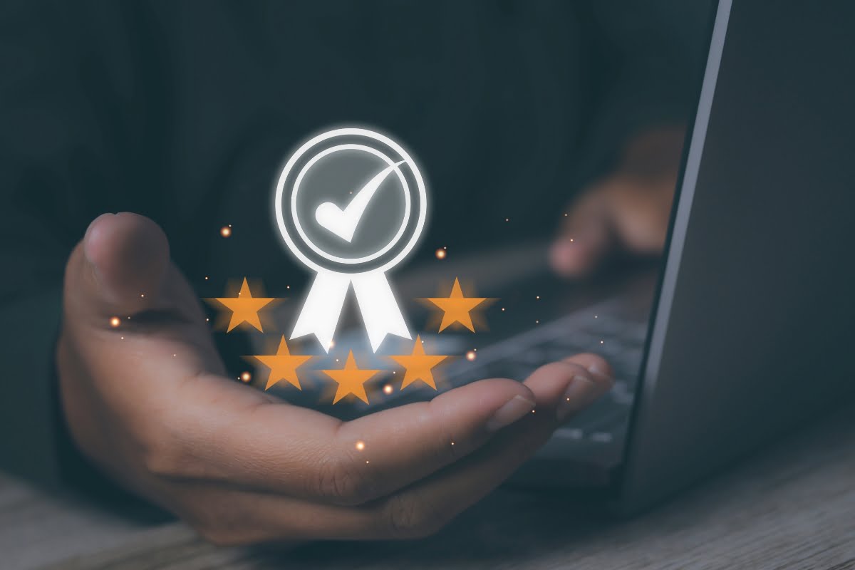 Person using a laptop with an overlay graphic of a checkmark badge and five stars, symbolizing quality or certification, ideal for those choosing the right HVAC contractor.