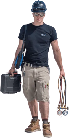 A person in a black shirt and shorts wears a hard hat, embodying reliable heating and air as they carry a toolbox in one hand and equipment with gauges in the other.