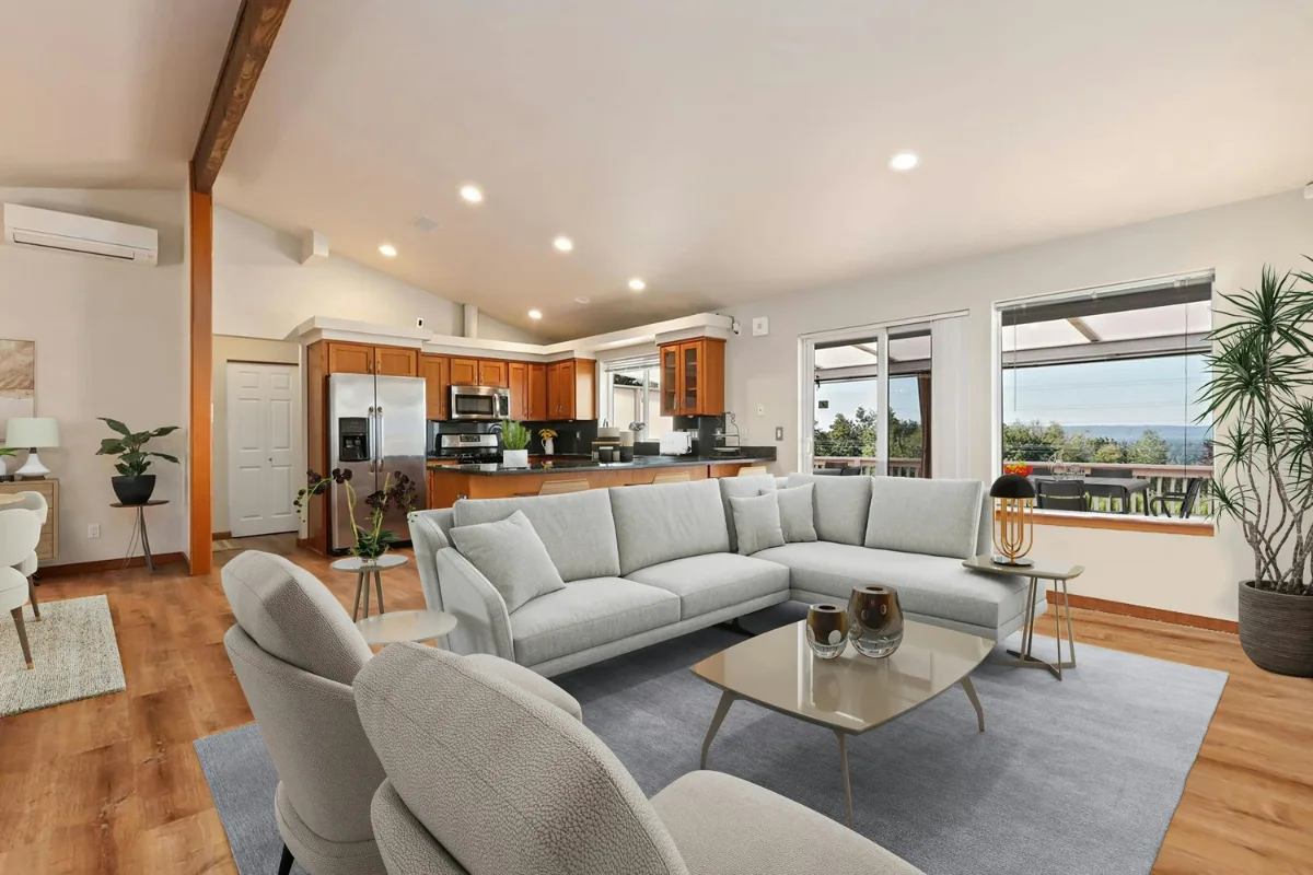 Modern open-concept living room and kitchen with light-colored furniture, wood flooring, large windows, potted plants, and a state-of-the-art HVAC system for year-round comfort.